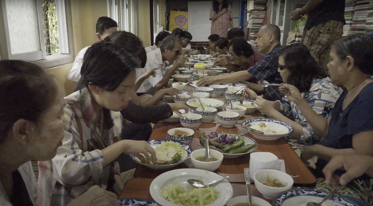 Photo of a group people eating around a table